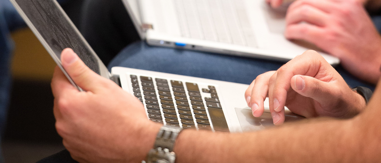 Close-up of hands on laptops